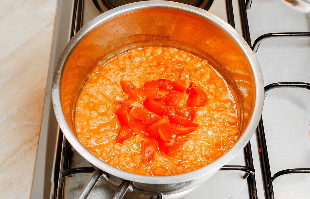 Чечевичный суп в кастрюле. Измельченные помидоры добавляют в сотейник. Покрошила в кастрюлю. Чечевица сварить в кастрюле. Красная чечевица варить по времени